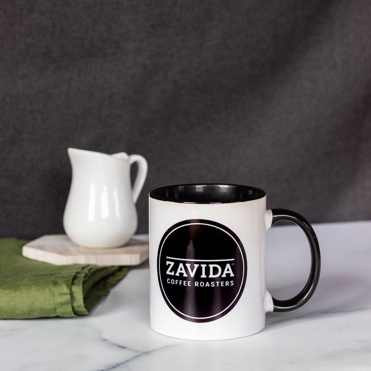 Zavida Coffee Roasters white coffee mug with a black logo in a kitchen setting